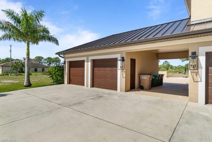 The property features a concrete driveway and two brown garage doors