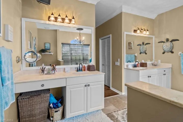 This bathroom features two vanity areas, each with a mirror and overhead lighting