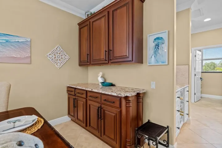 This space features extensive wooden cabinetry with a granite countertop, offering ample storage and surface area