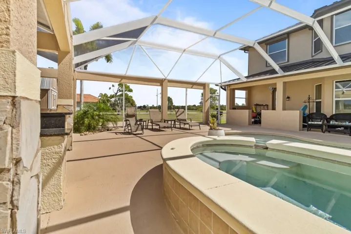 The property features a screened-in patio area with a swimming pool and spa