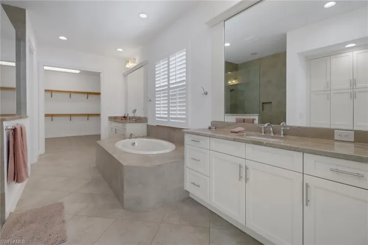 Bathroom featuring vanity, separate shower and tub, and tile patterned flooring