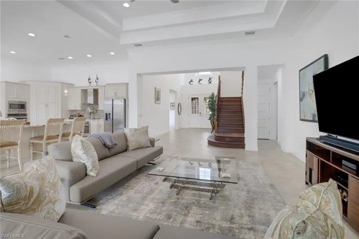 Living room featuring light tile patterned floors and a tray ceiling