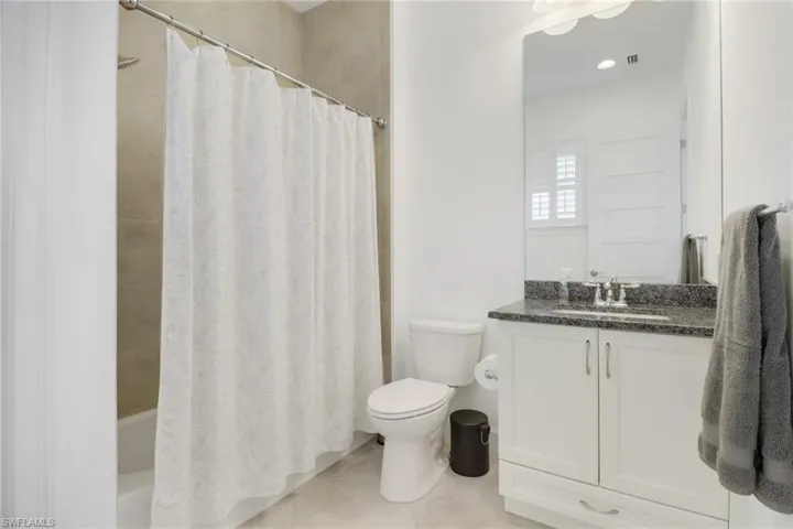 Full bathroom with vanity, toilet, tile patterned floors, and shower / tub combo with curtain