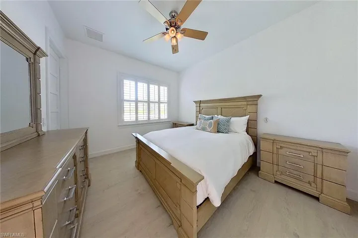 Bedroom featuring ceiling fan, vaulted ceiling, and light hardwood / wood-style flooring