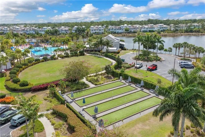 Expansive communal grounds featuring four bocce ball courts, a manicured lawn, and lush landscaping