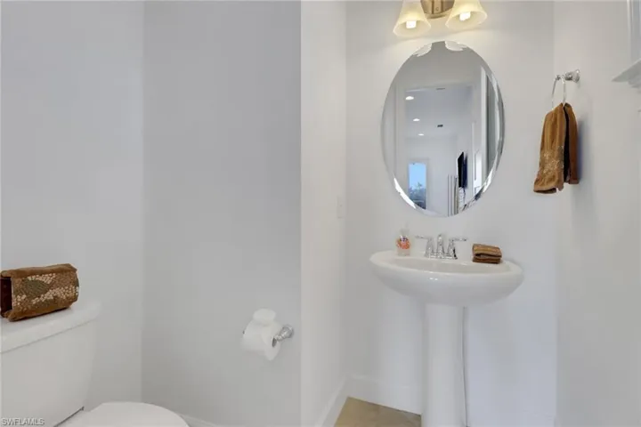 Bathroom featuring toilet, sink, and tile patterned flooring