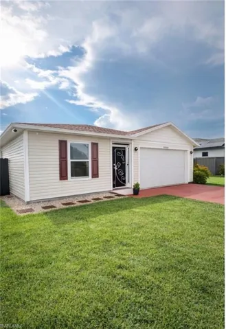 Ranch-style home featuring concrete driveway and an attached garage