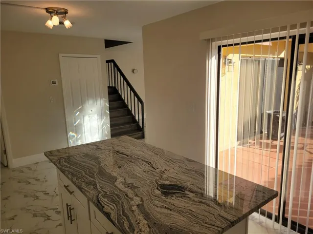 Kitchen with white cabinetry and dark stone countertops