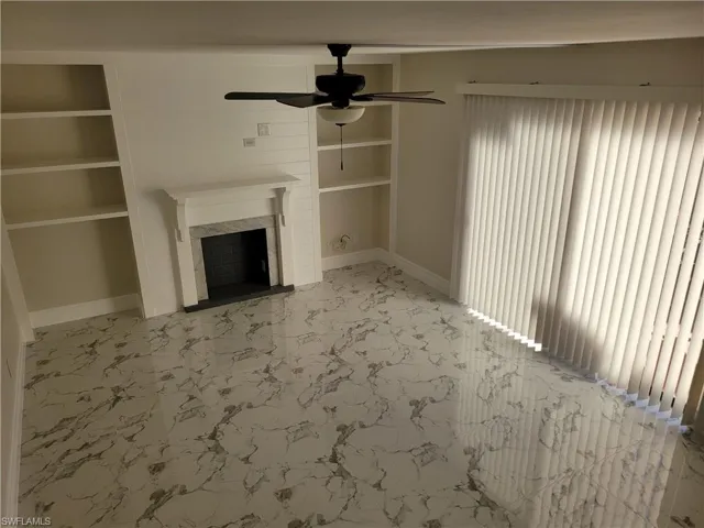 Unfurnished living room featuring ceiling fan