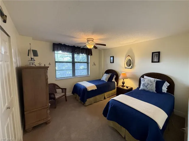 Bedroom featuring carpet flooring, ceiling fan, and a textured ceiling