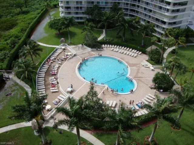 Drone / aerial view of a pool and apartment complex