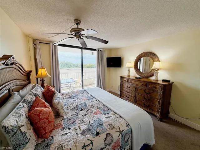 Bedroom featuring access to outside, a textured ceiling, carpet, and ceiling fan