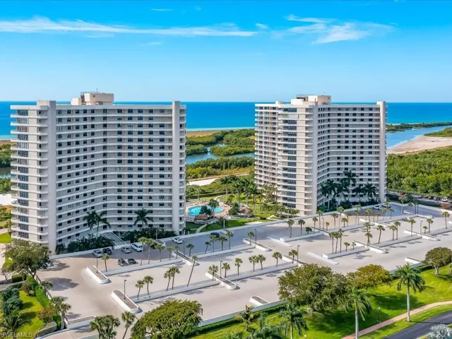 Drone / aerial view of apartment complex / building and a nearby body of water