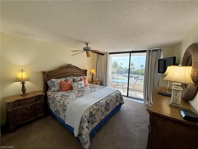 Bedroom featuring carpet floors, access to outside, a textured ceiling, a ceiling fan, and floor to ceiling windows
