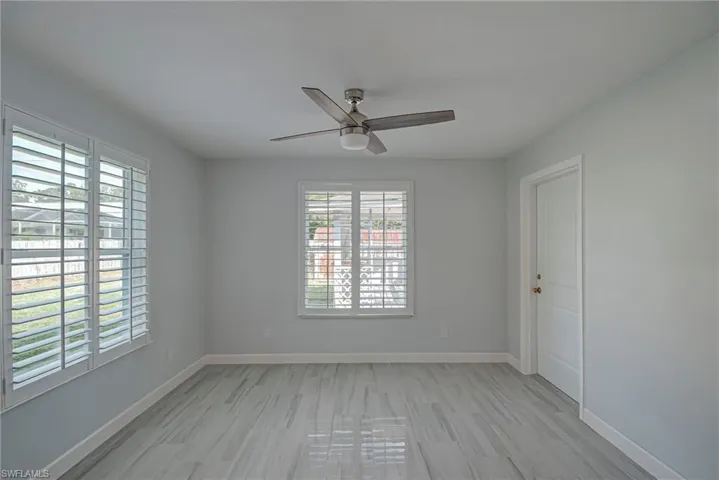 Empty room with a ceiling fan and light wood-style floors
