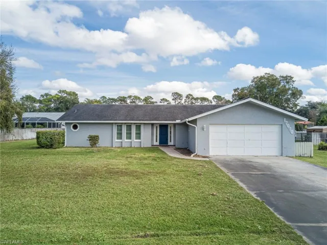 Single story home with stucco siding, concrete driveway, and a garage