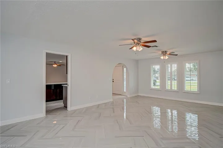 Unfurnished room with a ceiling fan and arched walkways