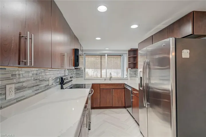 Kitchen with stainless steel appliances, open shelves, light stone countertops, modern cabinets, and recessed lighting