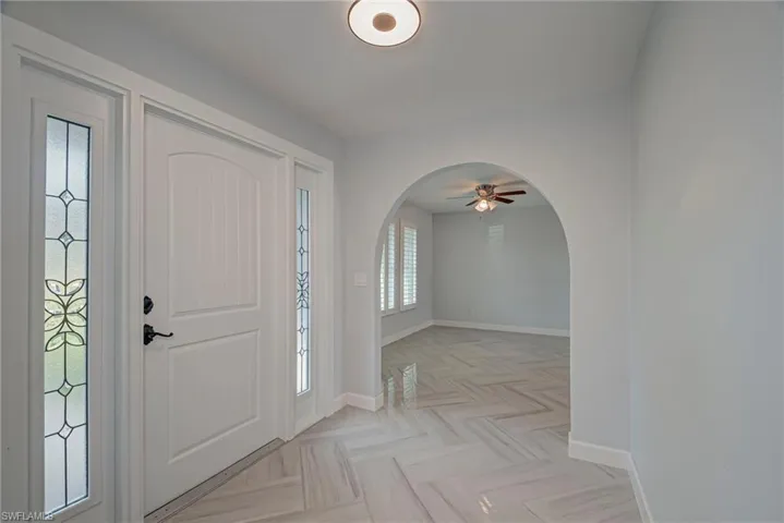 Entrance foyer with arched walkways and a ceiling fan