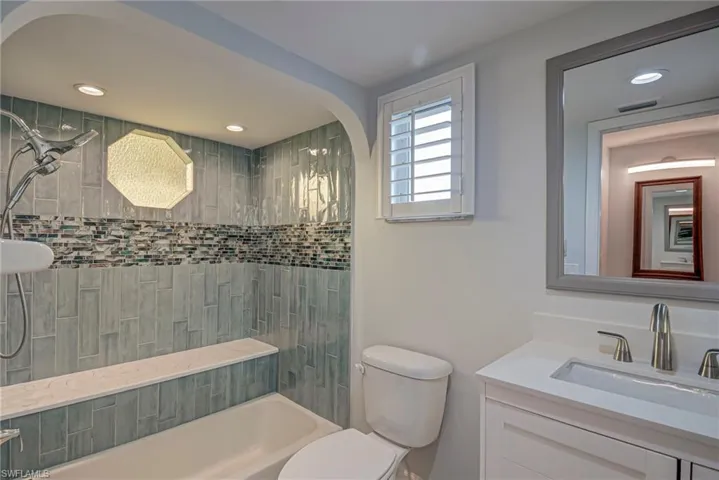 Bathroom with vanity, recessed lighting, and tiled shower / bath