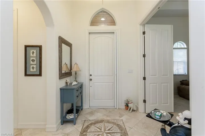 Travertine tile throughout with custom terrazzo insert in foyer