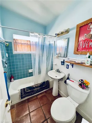 Full bathroom featuring tile patterned floors, sink, shower / bath combination with curtain, and toilet