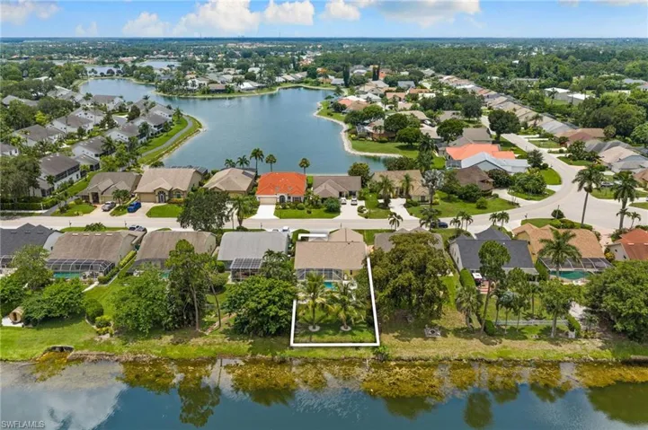 Waterfront property featuring a private pool, screened lanai, mature landscaping, and an expansive backyard