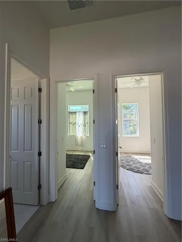 Hall featuring light wood-style flooring and healthy amount of natural light