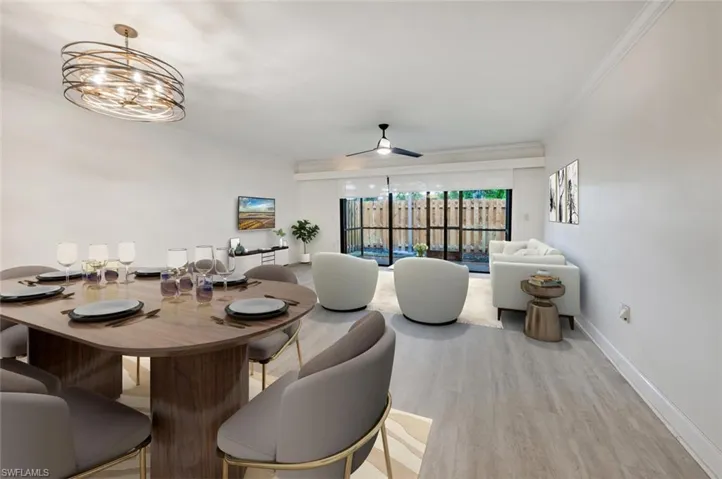 Dining area featuring ceiling fan with notable chandelier, crown molding, and light hardwood / wood-style flooring