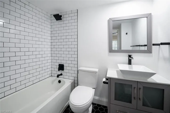 Full bathroom featuring tile patterned flooring, vanity, toilet, and tiled shower / bath combo