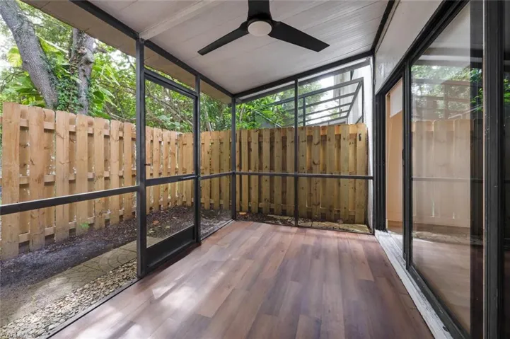 Unfurnished sunroom with lofted ceiling, ceiling fan, and a wealth of natural light