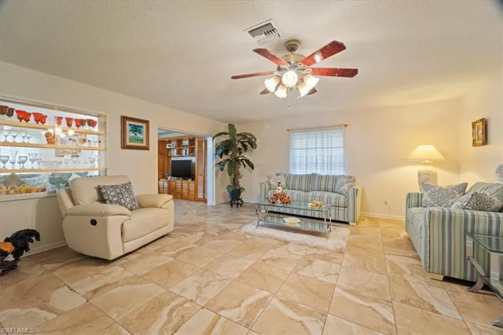 Living room featuring a textured ceiling and ceiling fan