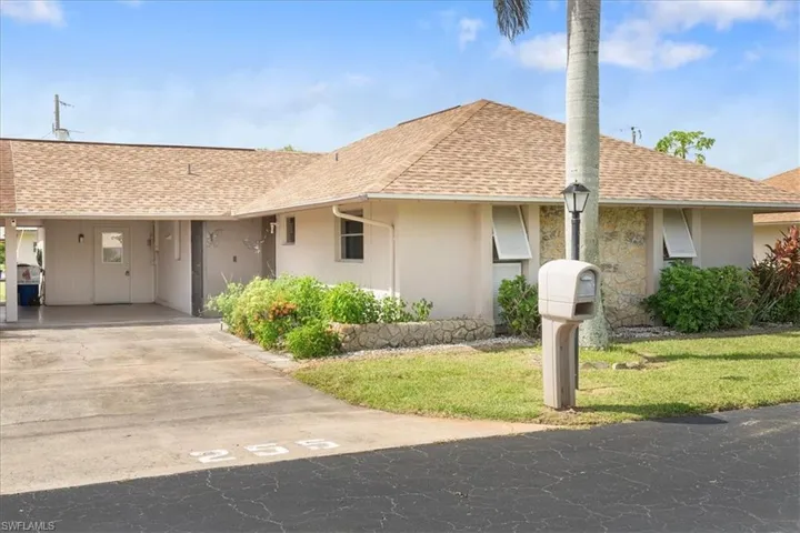 Single story home with a front yard and a carport