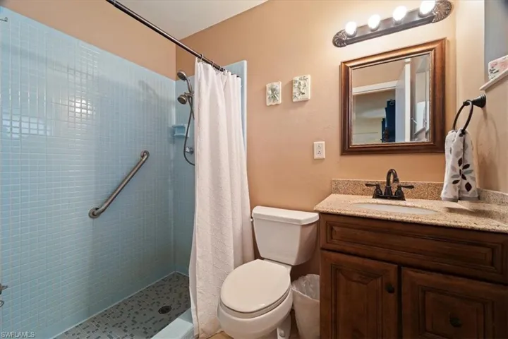Bathroom with vanity, toilet, and walk in shower