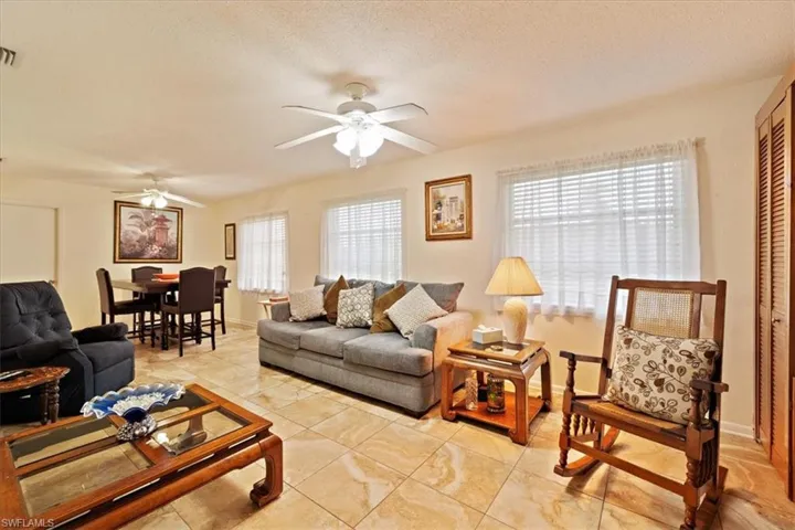 Living room with ceiling fan and a textured ceiling