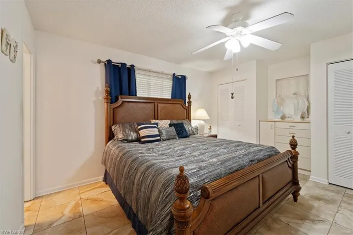 Bedroom with ceiling fan and a textured ceiling
