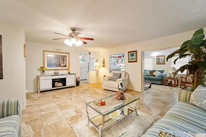 Living room featuring ceiling fan and a textured ceiling
