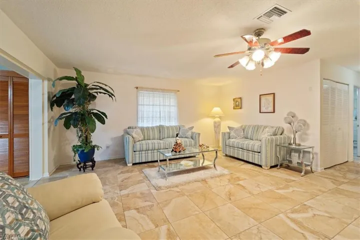 Living room featuring ceiling fan and a textured ceiling