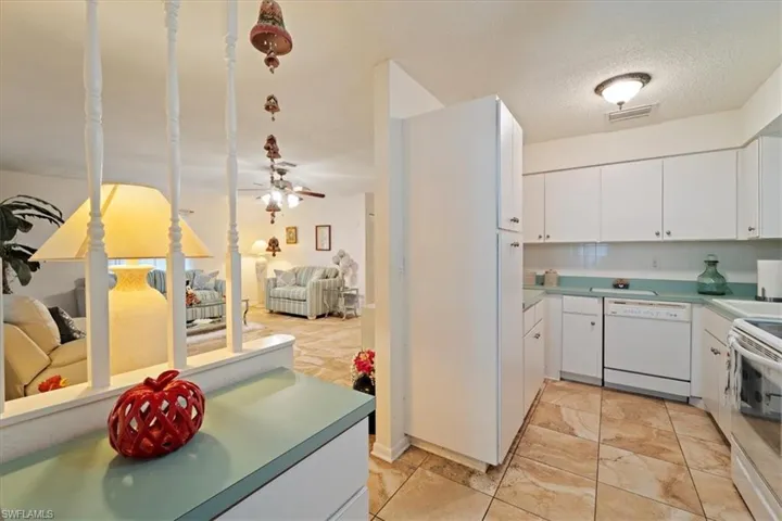 Kitchen featuring ceiling fan, dishwasher, stove, a textured ceiling, and white cabinets