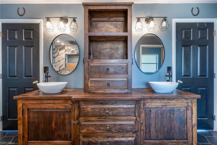 Bathroom with dual bowl vanity and tile flooring