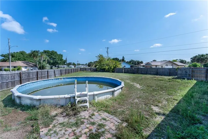 View of pool with a lawn