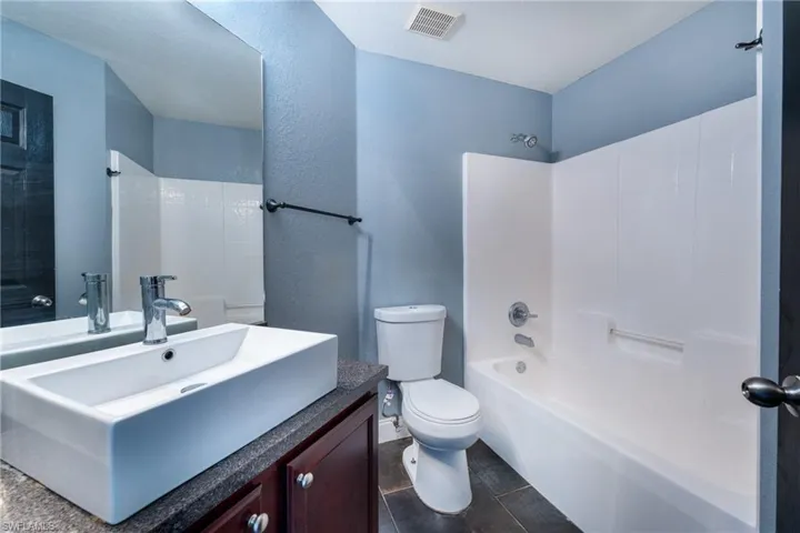 Full bathroom featuring tile floors, shower / washtub combination, large vanity, and toilet