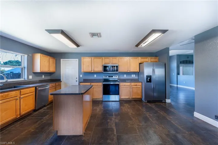 Kitchen with a center island, sink, and appliances with stainless steel finishes