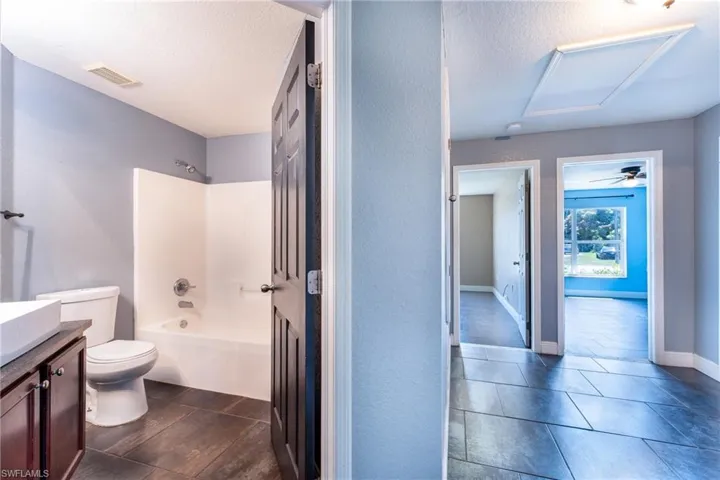 Full bathroom featuring ceiling fan, shower / bathing tub combination, tile floors, toilet, and vanity