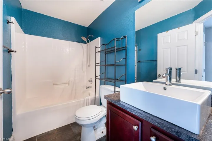 Full bathroom with tile flooring, vanity, toilet, and bathing tub / shower combination