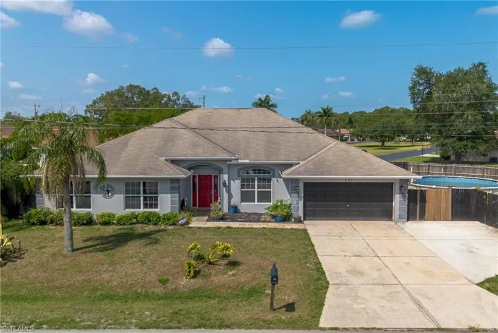 Ranch-style home featuring a garage and a front lawn