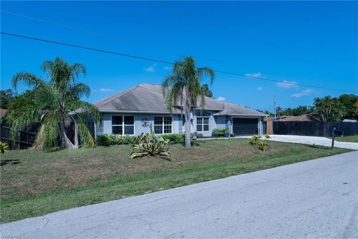 Single story home with a garage and a front yard