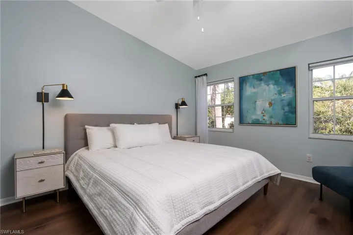 Bedroom with wood finished floors, lofted ceiling, and a ceiling fan