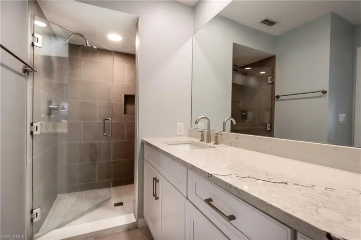 Bathroom with vanity, a shower stall, and recessed lighting