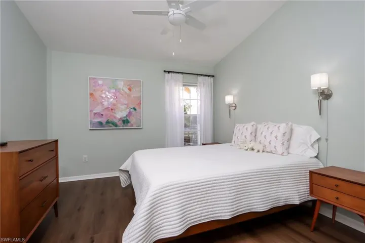 Bedroom with lofted ceiling, dark wood-style flooring, and ceiling fan